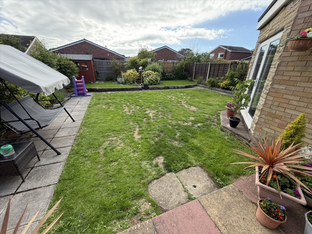 A garden lawn with distinct bare patches among the grass