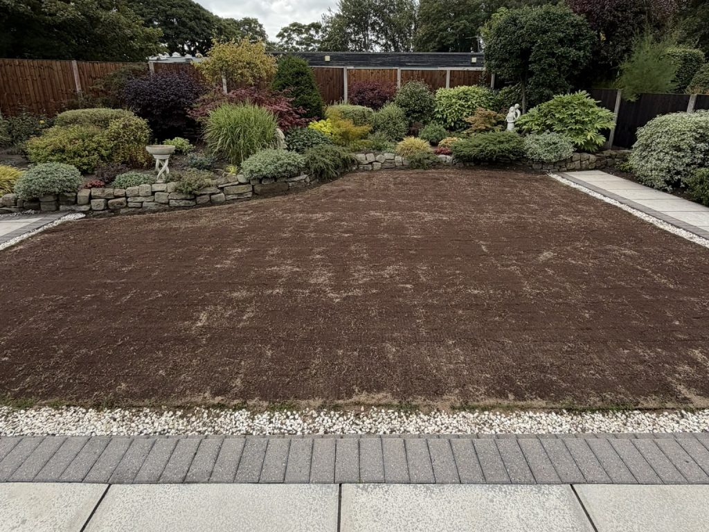 A level soil surface prepared within the edges of a garden lawn
